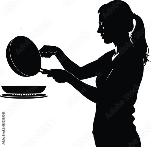Silhouette of woman cooking with frying pan over stovetop