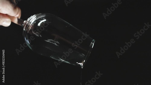 emptying a glass of sherry on a black background