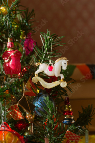 Old vintage Christmas ornament horse from Soviet childhood on branch of artificial miniature tree, selective focus