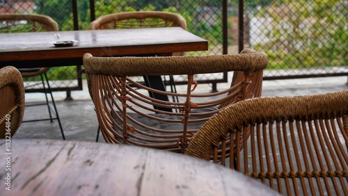Aesthetic rattan chairs in an outdoor area with wooden tables, creating a relaxing atmosphere