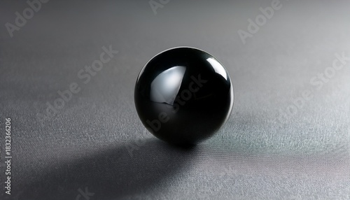 a shiny black sphere rests on a gray surface