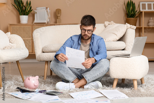 Young man in debt with pape...
