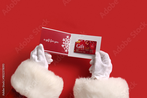 Wallpaper Mural Santa Claus holding gift card on red background, closeup Torontodigital.ca