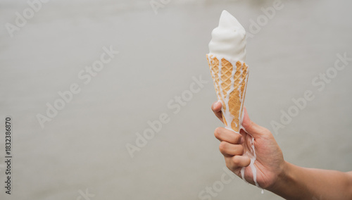 Melting ice cream cone hand holding ice cream waffle cone soft serve ice cream summer treat melting dessert cold snack sweet food outdoor food creamy texture