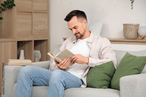 Handsome man reading book o...