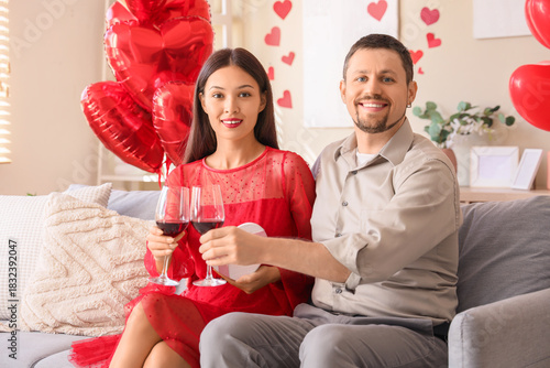 Young couple with wine sitt...