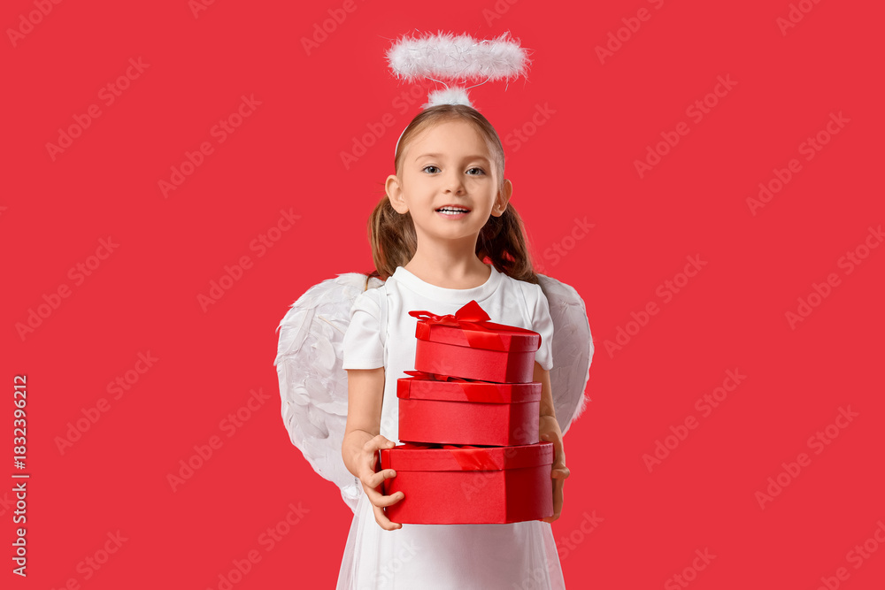 Fototapeta premium Cute little girl dressed as Cupid with gift boxes on red background. Valentine's Day celebration