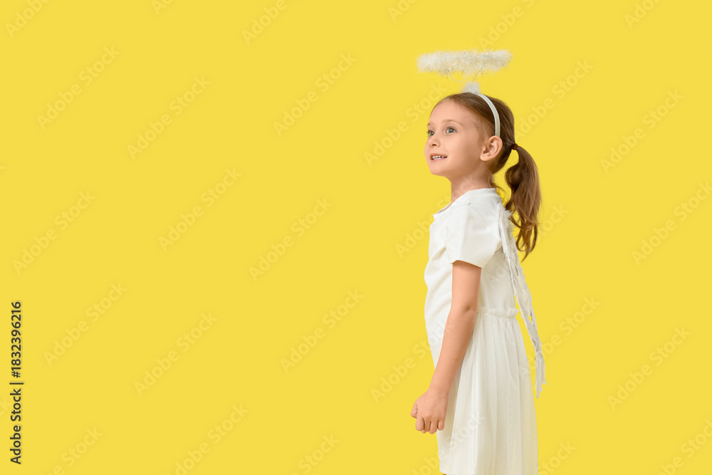 Fototapeta premium Cute little girl dressed as Cupid on yellow background. Valentine's Day celebration