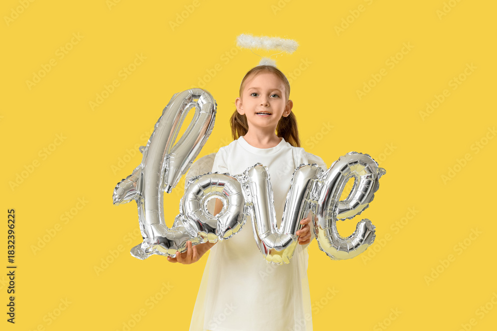 Fototapeta premium Cute little girl dressed as Cupid with air balloons in shape of word LOVE on yellow background. Valentine's Day celebration