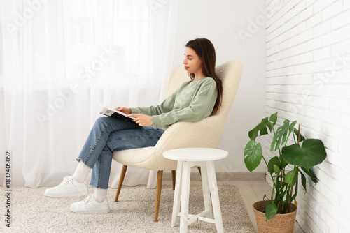 Young woman reading magazin...