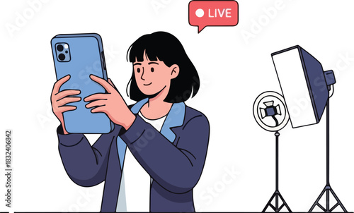 A woman records a live video on her smartphone with a softbox light.