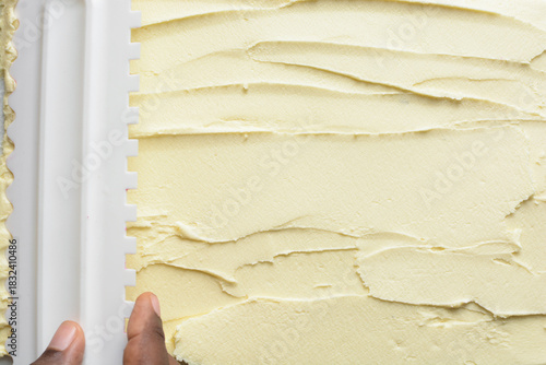 Overhead view of silky body butter being spread with spatula, top view of pattern being made in cream or body butter