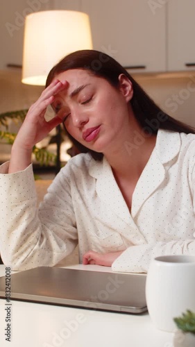 Young woman at night home shuts laptop after work feels burnout wants pause takes breath. Caucasian girl on sofa at table at evening looks tired says enough rubs temples needs break rests eyes closed.