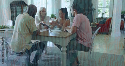 Discussing four adults in casual clothes reviewing paperwork at home dining area, with notebook