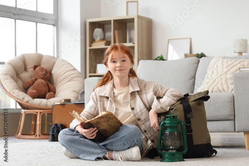 Young redhead girl reading ...