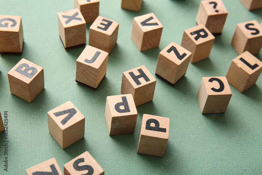 Fototapeta premium Wooden cubes with English letters on green background