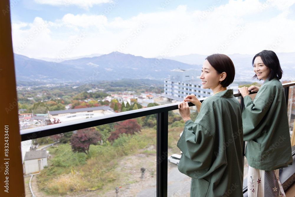 Naklejka premium 女子旅 温泉旅館 屋外の景色を眺める女性