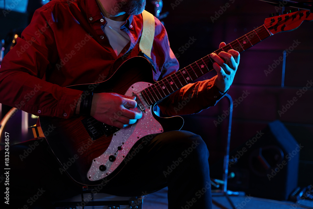 Obraz premium Man playing electric guitar on stage, closeup