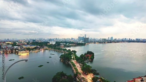 Timelapse of Hanoi city, Vietnam with road crossing the island lake with green tree lined street, temple located between small oasis.