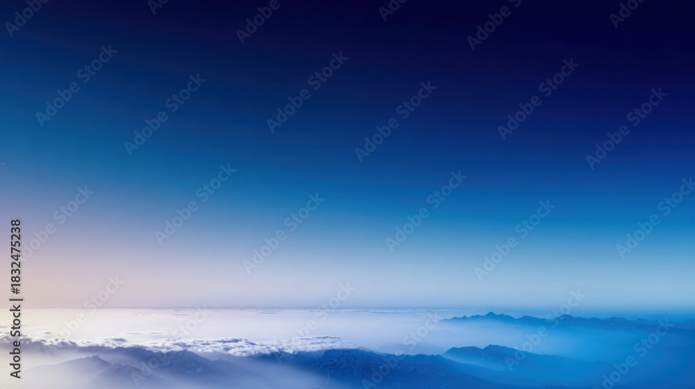 Obraz premium A breathtaking aerial view of mountains and clouds under a serene gradient sky, showcasing the beauty of nature.