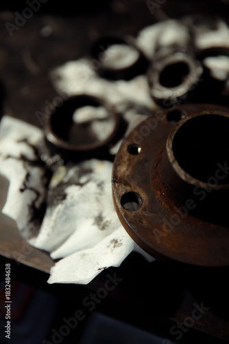Replacing a wheel bearing in a classic car. Old vehicle restoration concept. Worn wheel bearing on a dirty, oily napkin. Metal textured background.