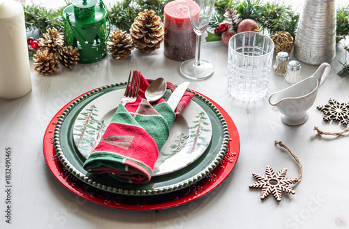 An elegant holiday place setting with Christmas decorations all around. 