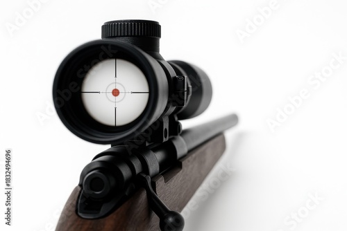 Close up sniper scope mounted on rifle barrel with visible crosshair and blurred bullseye target on clean studio background