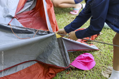 Slika na platnu Young child with focus pitching tent for family camping adventure