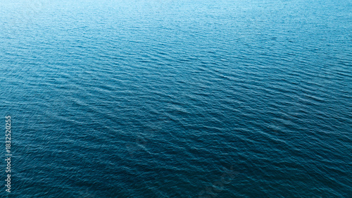 Top view of deep blue sea water surface with small ripples, aerial drone shot of turquoise ocean texture at island , abstract nature background	