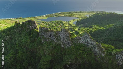 Moorea island landscape presenting a panoramic aerial view of lush tropical mountains, a tranquil lake, a small community, a coastal airport runway, and the deep blue Pacific Ocean