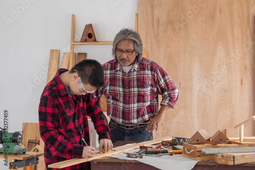 Asia retirement carpenter man spends time with cheerful granddaughter in carpentry studio, aged people enjoy teaching woodwork skill to adorable niece, family hobby lifestyle parenthood DIY handmade