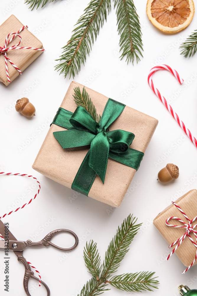 Obraz premium Christmas composition with gift boxes, fir tree branches, threads and scissors on white background, closeup