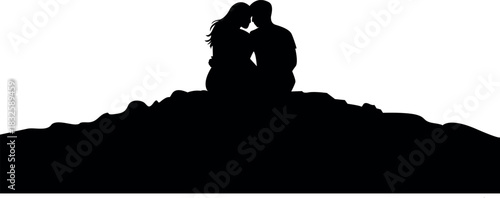 Silhouette of a romantic couple sitting on a hill