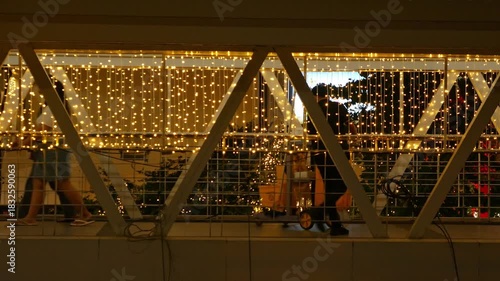 Cleaning Staff Working During Holiday Season: Janitor with Cart in Illuminated Building with Christmas Lights Decoration at Night