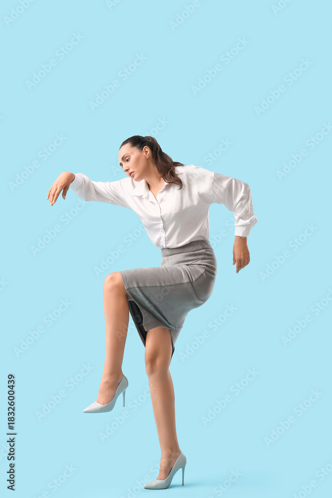 Obraz premium Businesswoman in pose of marionette on blue background