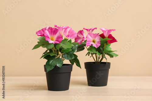 Wallpaper Mural Pink artificial flowers on table near beige wall Torontodigital.ca