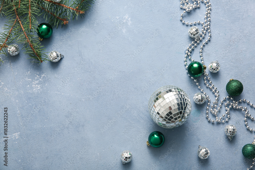 Naklejka premium Frame made of disco balls, fir tree branch and Christmas decor on blue grunge background