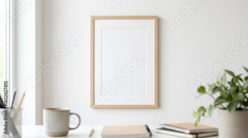 Blank Frame Mockup on a White Wall, Above a Minimalist Desk with Office Supplies in a Bright Home Office
