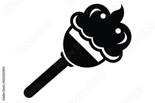 A black silhouette candy wand has decorative frosting and a stick handle