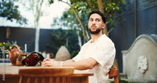 Thinking, waiting and man with flowers, date delay and contemplation with Valentines day. Home, bouquet and person with stress, stood up or wonder with reflection, frustrated or annoyed with concern