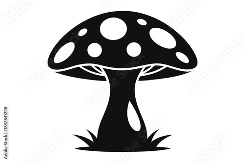 Solid black mushroom with white spots grows among blades of grass below