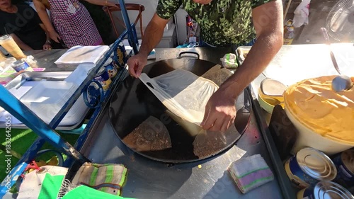 Culinary Craft: A skilled vendor meticulously crafts savory crepes on a bustling street, capturing the essence of street food culture. 