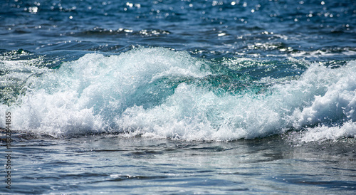 Fototapeta Naklejka Na Ścianę i Meble -  Rolling sea waves movement. Wave background. Soft sea waves. Blue sea waves reflect sunlight. Abstract ocean texture. Transparent sea waves with foam sparkle.
