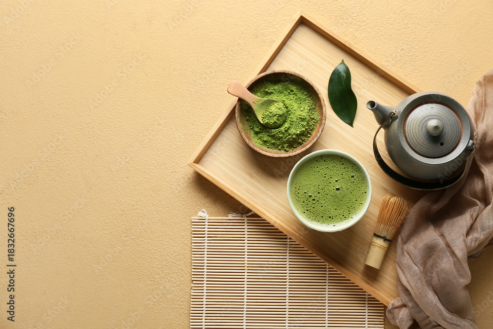 Fototapeta premium Composition with wooden tray, bowl of tasty matcha tea and teapot on beige grunge background