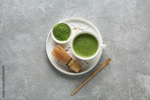 Photography Tray with cup of matcha tea and chasen on grey grunge background