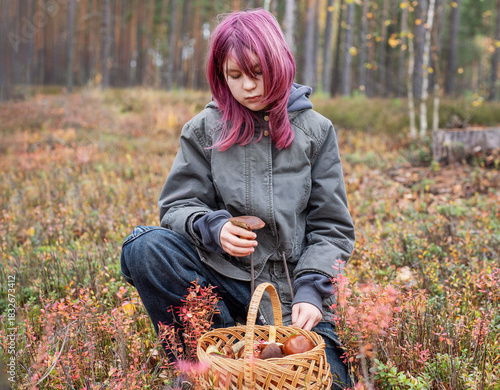 Girl foraging wild mushrooms in autumn forest