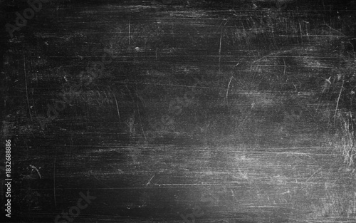 Blackboard texture background with dark wall backdrop. Rough grainy stone surface in black and dark gray tones. Vintage grunge wall with old textured design