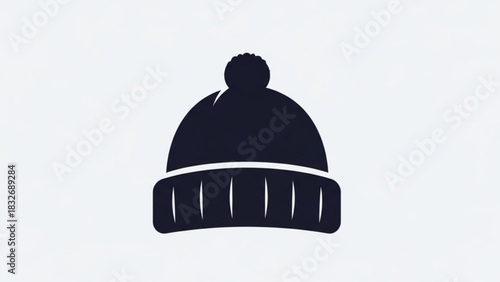 A minimalist dark blue knitted beanie with a pom pom on top and a ribbed brim isolated on a clean white background representing winter fashion and cold weather