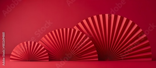 Festive display of three elegant red paper fan decorations in various sizes, set against a vibrant monochromatic red background