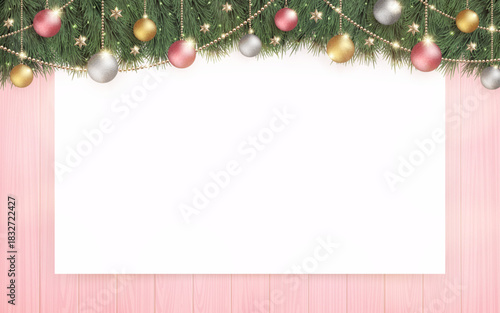 光輝くクリスマスツリーと、ピンクの木目の背景に白無地のボード